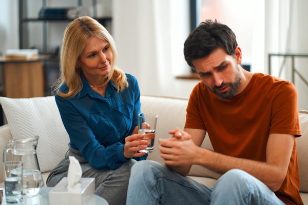 Young depressed man at the reception of a female psychologist during a mental health session. A man in frustrated feelings at a psychologist, being in a state of stress and poor mental health.